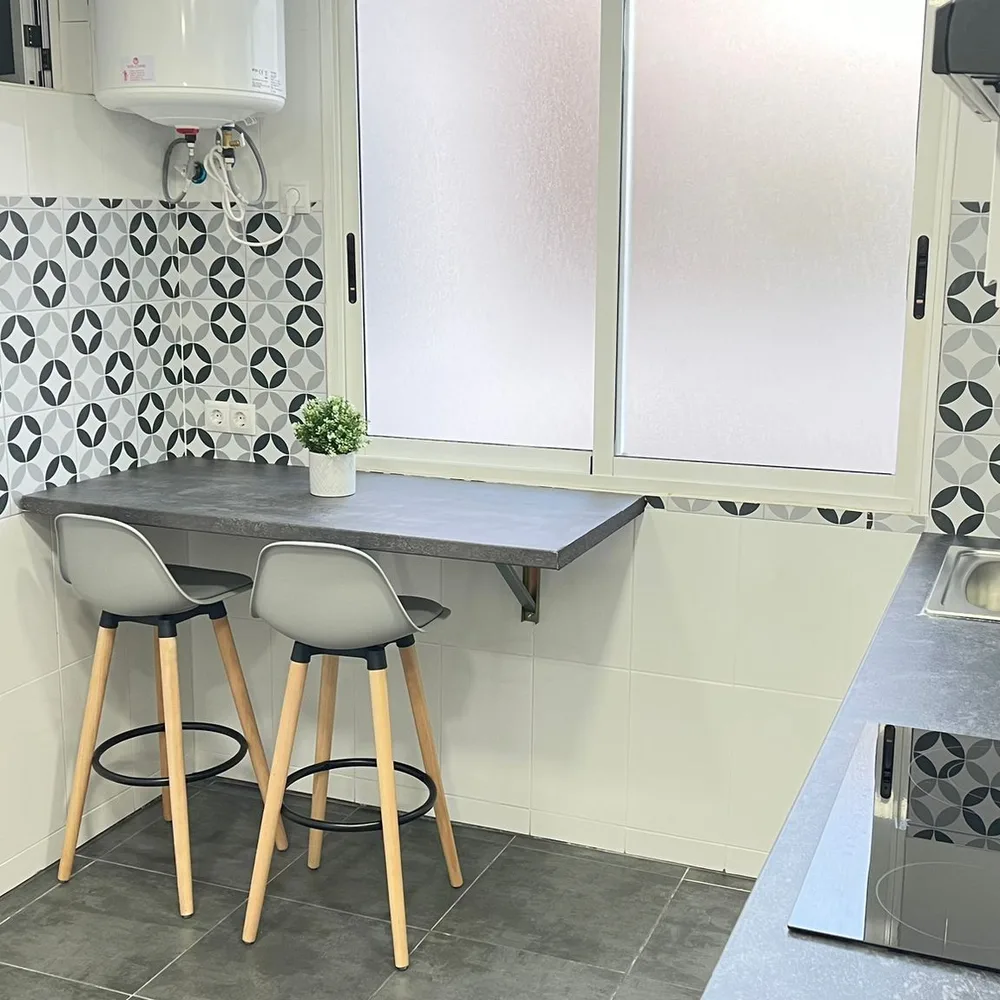 Barra de office en la cocina con taburetes, junto a la ventana