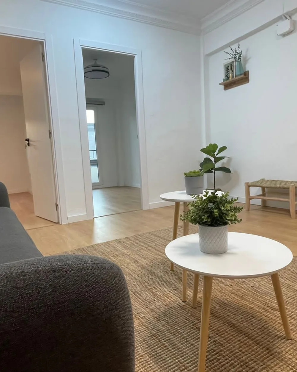 Vivienda terminada por ReformaNM: salón con suelo de madera y acabados claros